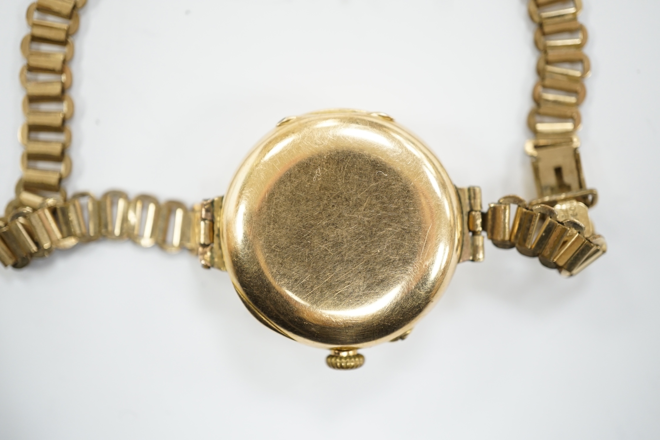 An early 20th century 15ct gold manual wind wrist watch, on a rolled gold bracelet.